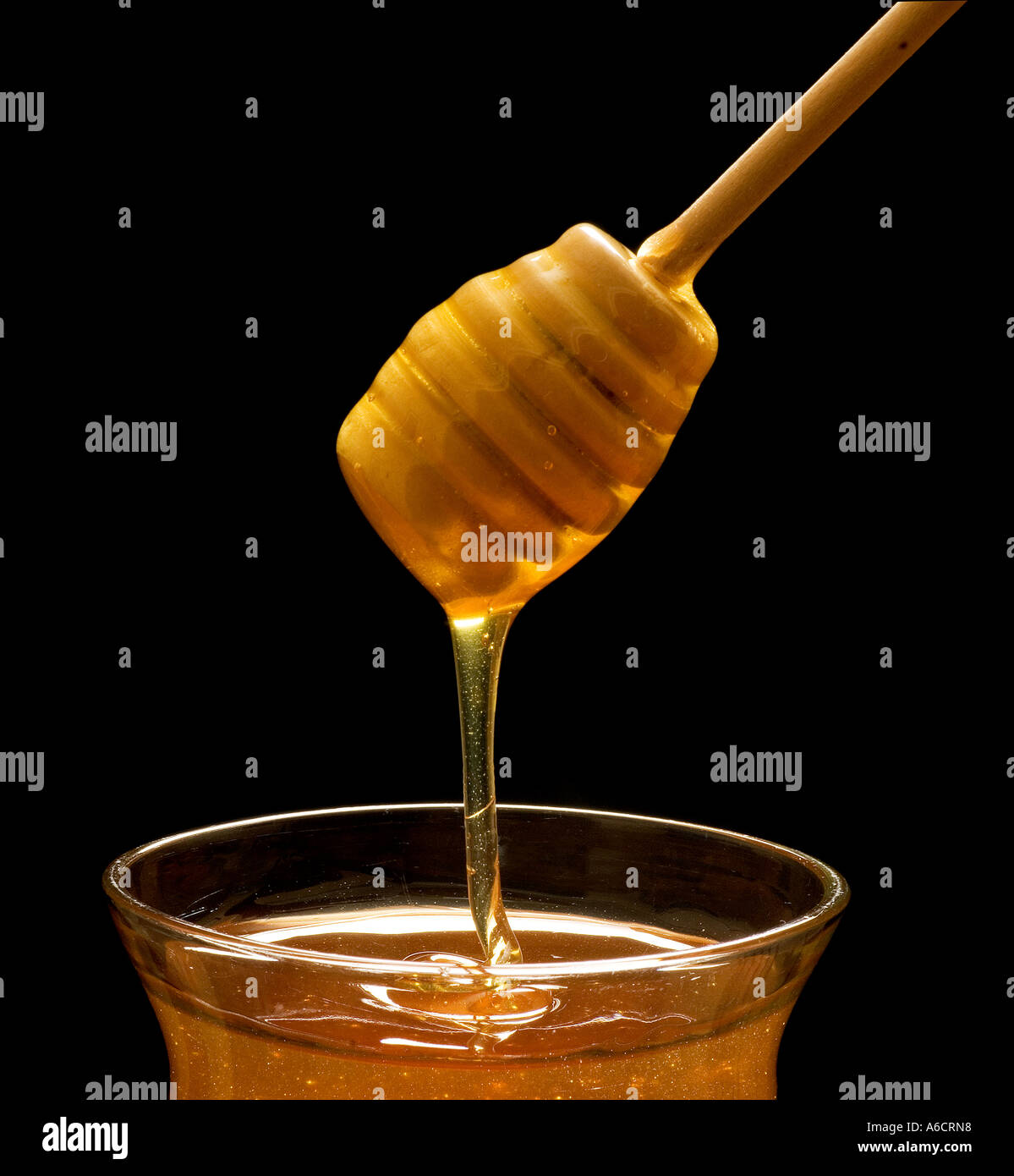 Honey drizzling into a container Stock Photo - Alamy