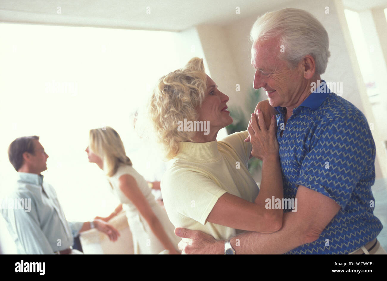portrait of mature couple, young couple in background arguing Stock Photo