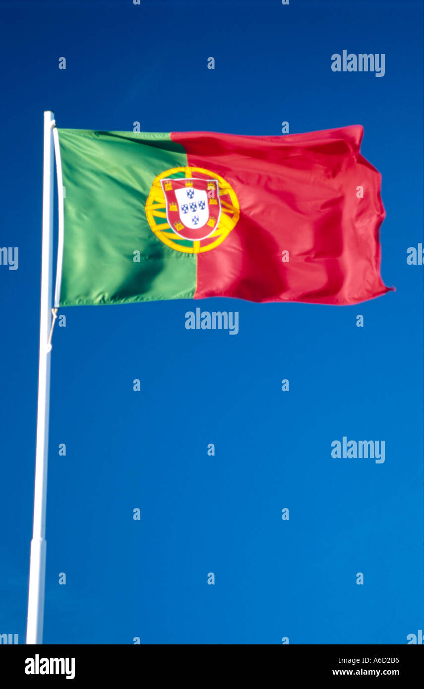 The Portuguese flag flutters against a blue sky. Stock Photo