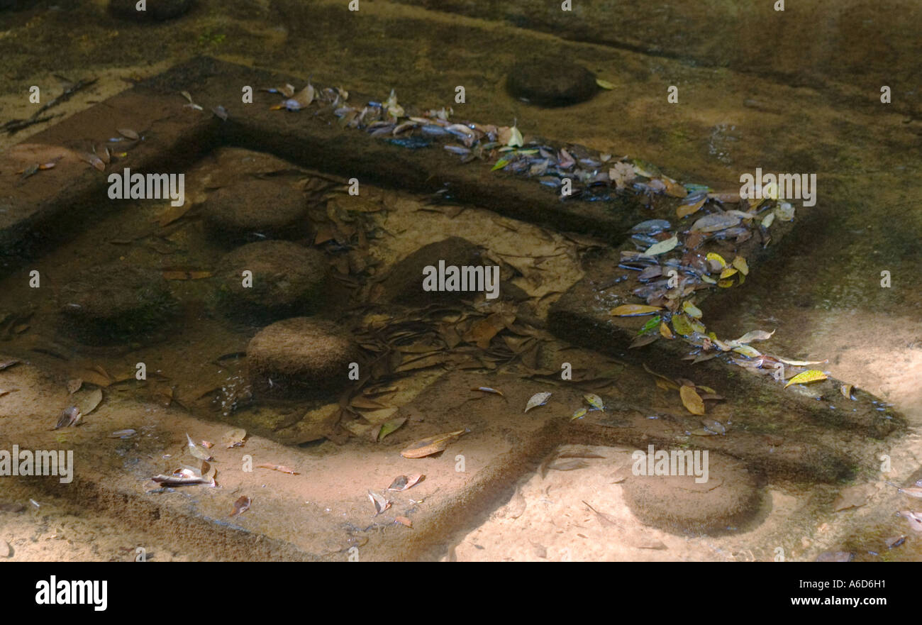 Water flows over stone carved yoni lingas in the River of a Thousand Lingas near Angkor Wat Siem Reap Cambodia Stock Photo