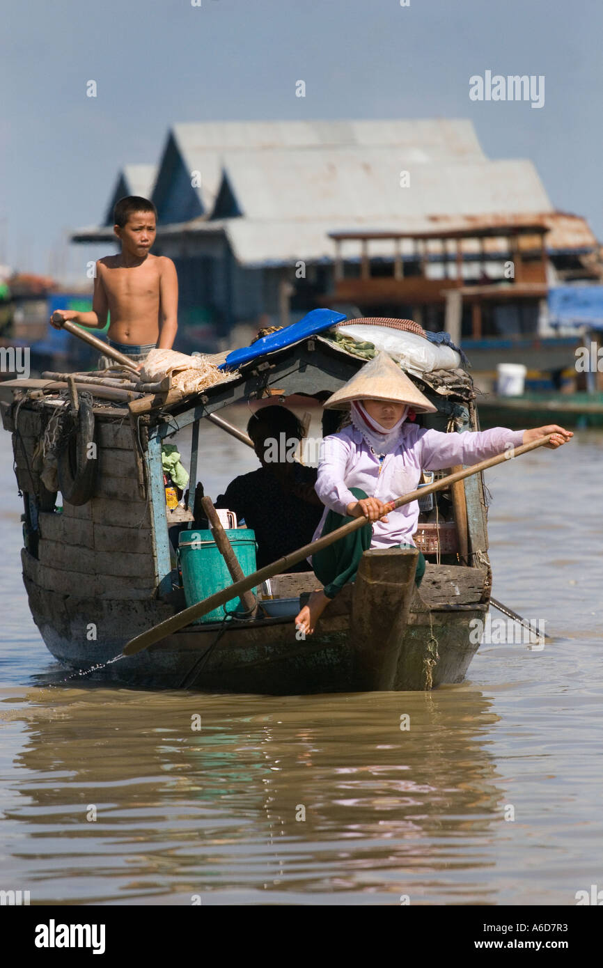 Polling a merchant boat in the Vietnamese floating village of Chong Kneas on lake Tonle Sap Siem Reap Cambodia Stock Photo
