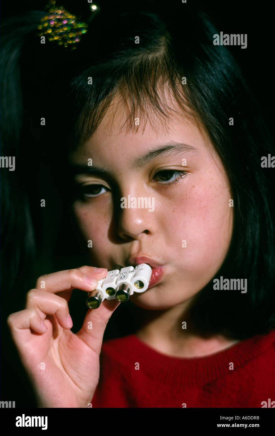 13792 nine year old girl uses pitch pipe Stock Photo
