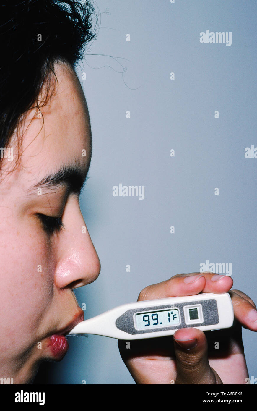 21656 Girl 13 years old, using a digital thermometer to take her temperature Stock Photo