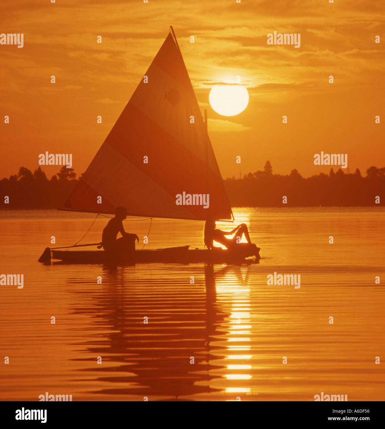 couple on sailboat on lake at sunset Stock Photo