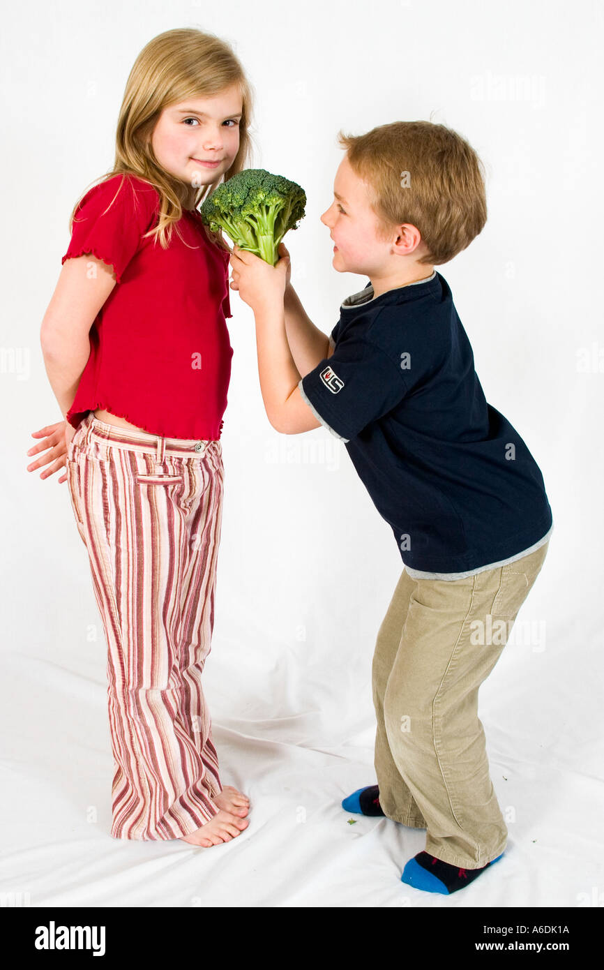 Boy offering broccoli to girl,portrait Stock Photo