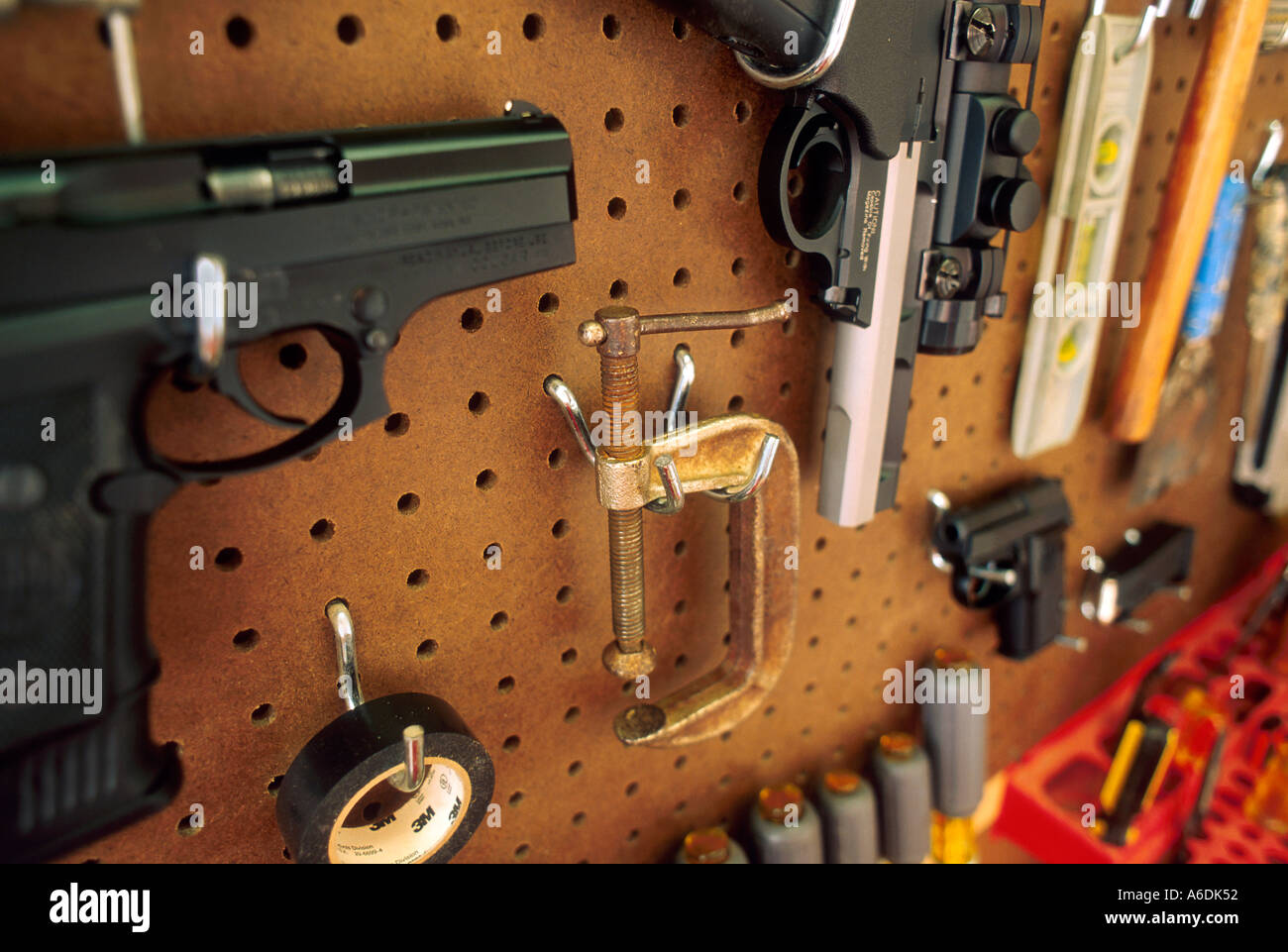 Guns as tools Handguns on pegboard with other tools in weapons