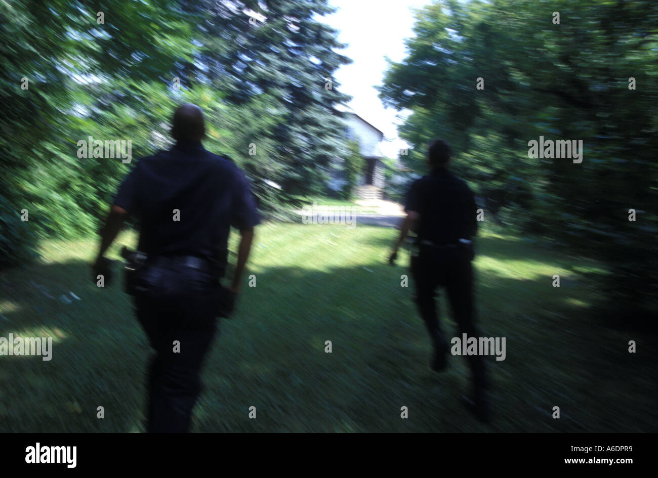 Detroit police officers chase after a suspect in a run down neighbourhood of Detroit Stock Photo