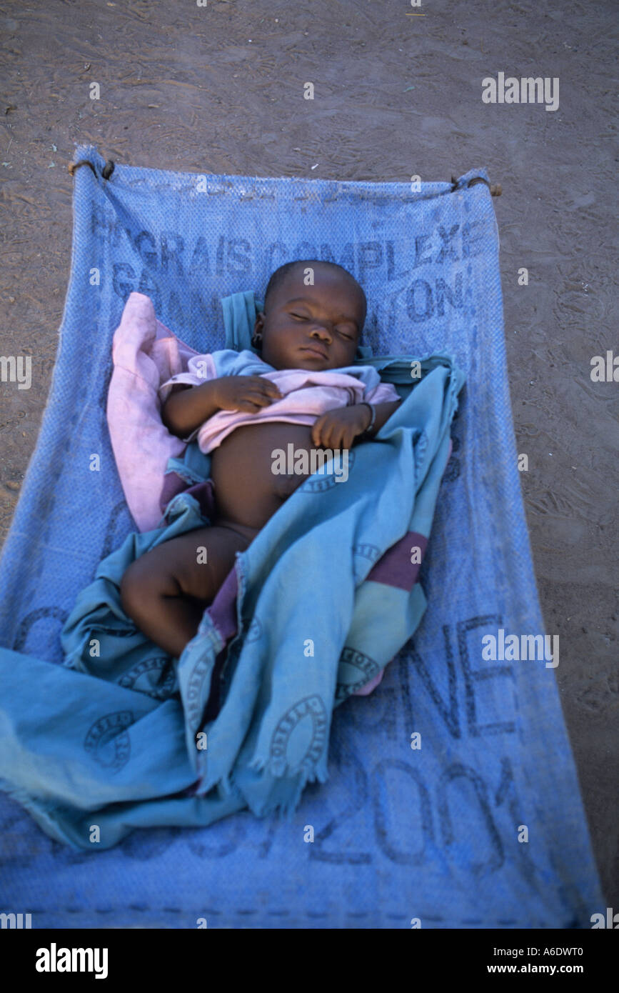 A baby on a grain sack Cotton farmer s village Salia in the Beleco region Mali Stock Photo