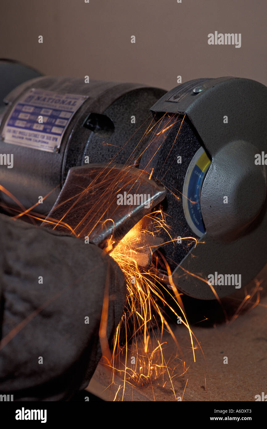 Sharpening an axe blade on an electric grinding wheel Stock Photo Alamy
