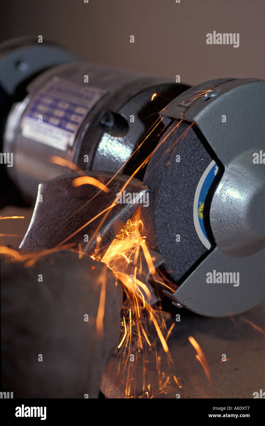Sharpening an axe blade on an electric grinding wheel Stock Photo Alamy