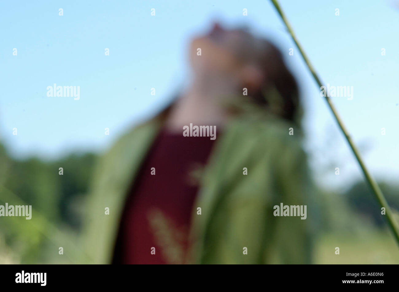 Blurred woman half figure with view into the sky Stock Photo