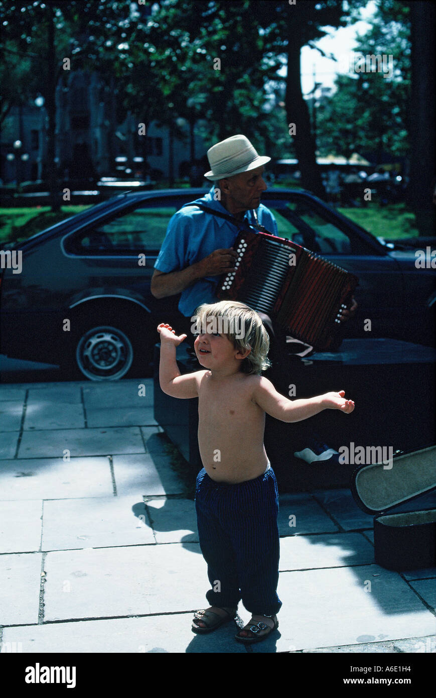 Child dancing to an accompanying accordian player. Street music, Quebec City, Canada. Stock Photo