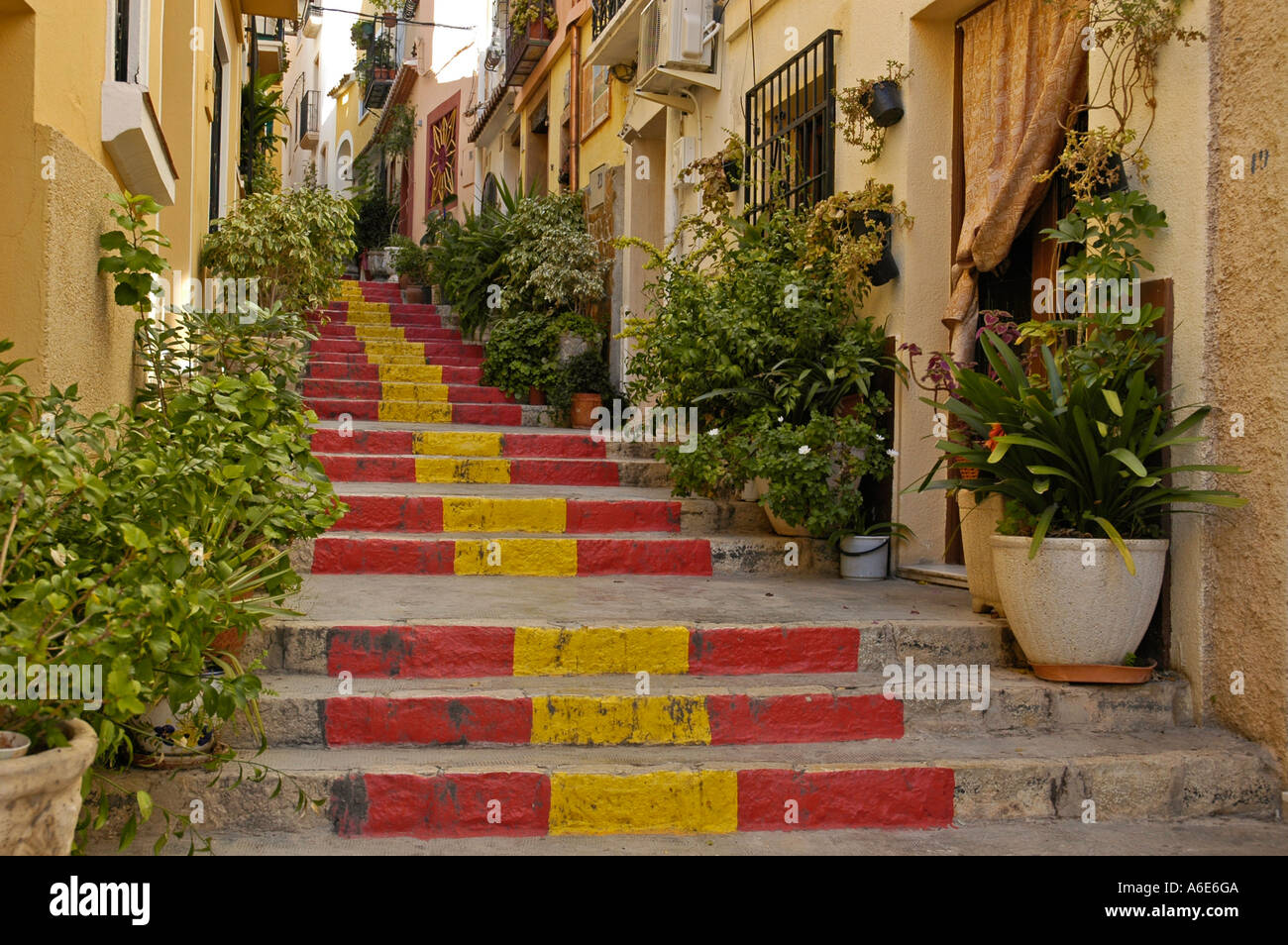 Steep lane with stairway steps in the Spanish national colors, old part