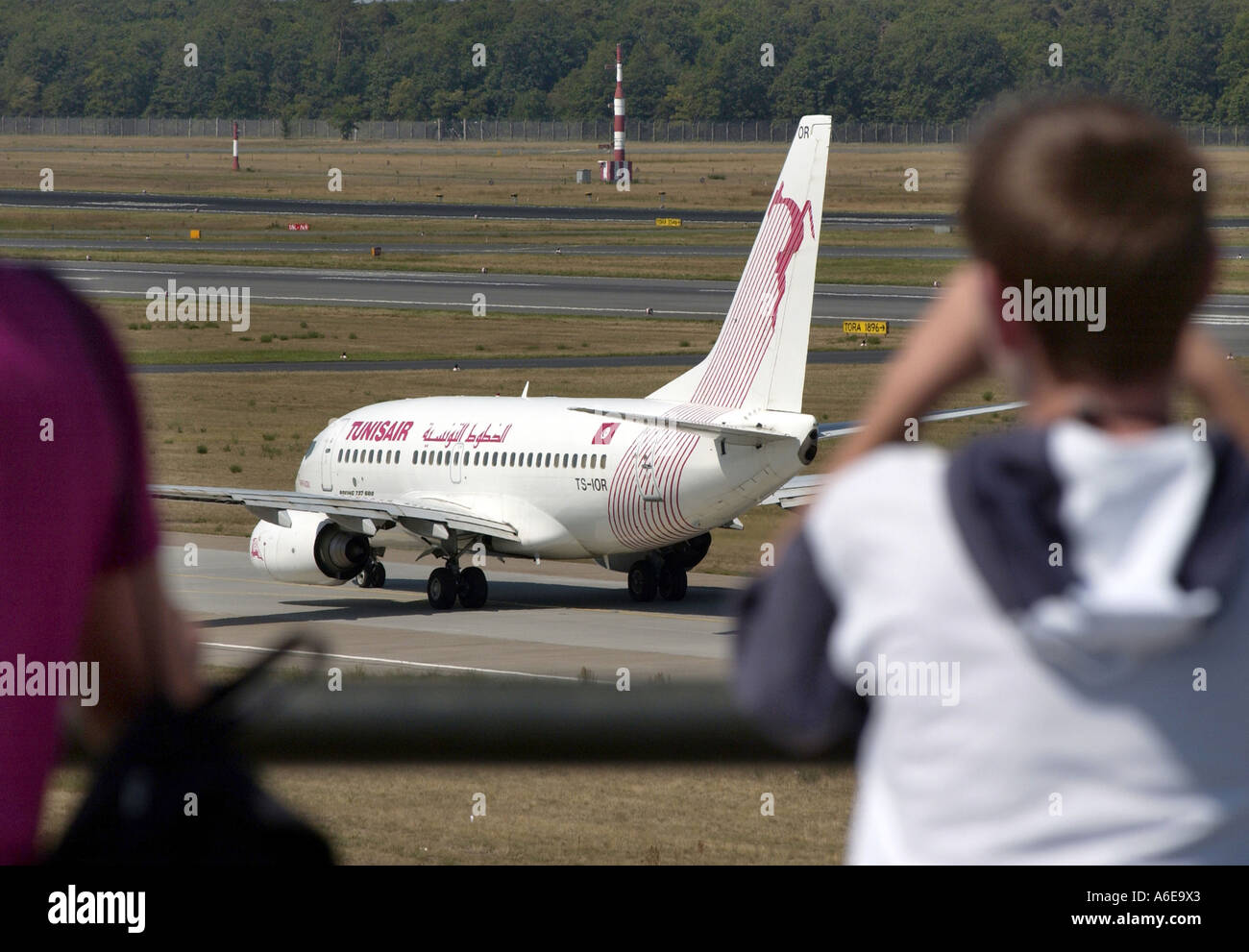 Plane spotters watching a TunisAir airplane at Tegel airport, Berlin Stock Photo