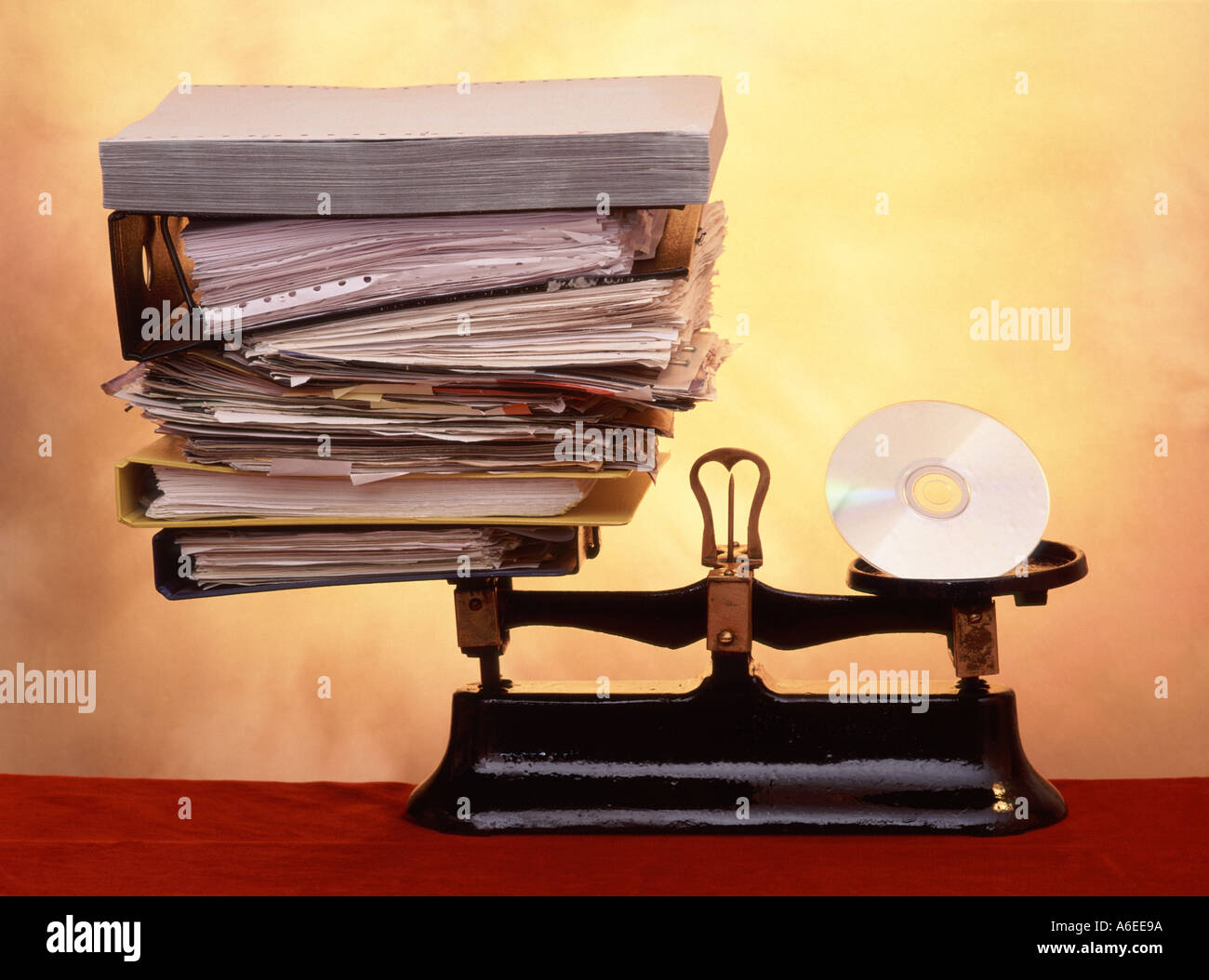 Weighing up benefits of digital CD technology for document storage compared with stacks of conventional business paper & hard copy filing space UK Stock Photo