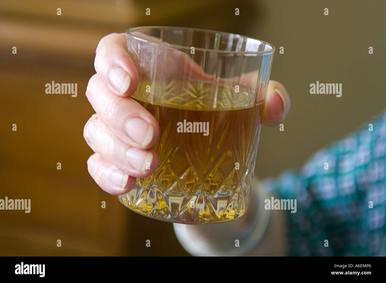 Close up of old lady holding whisky glass Stock Photo