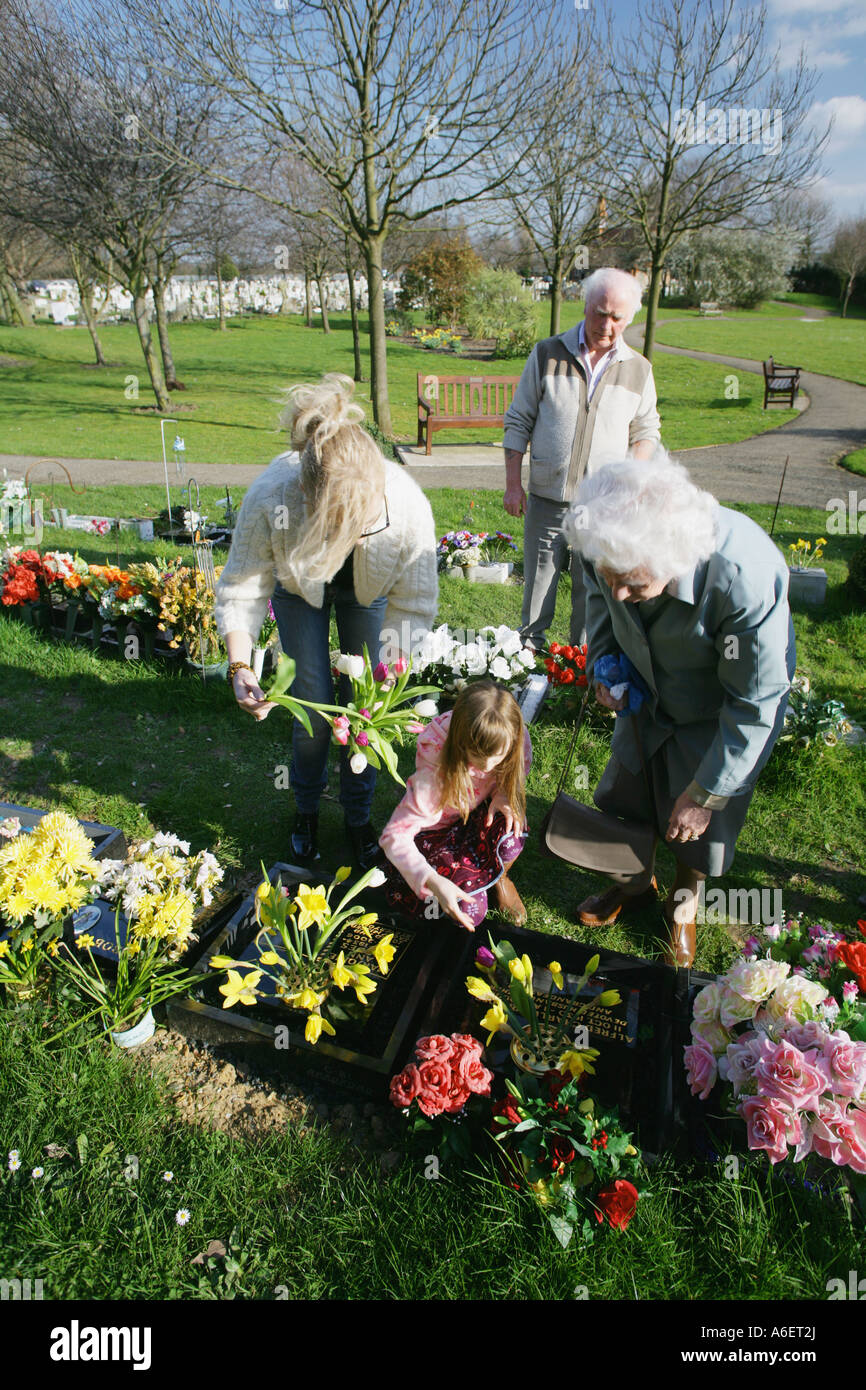Family members looking after the grave of a loved one at a cemetary, Essex, England, UK. Stock Photo