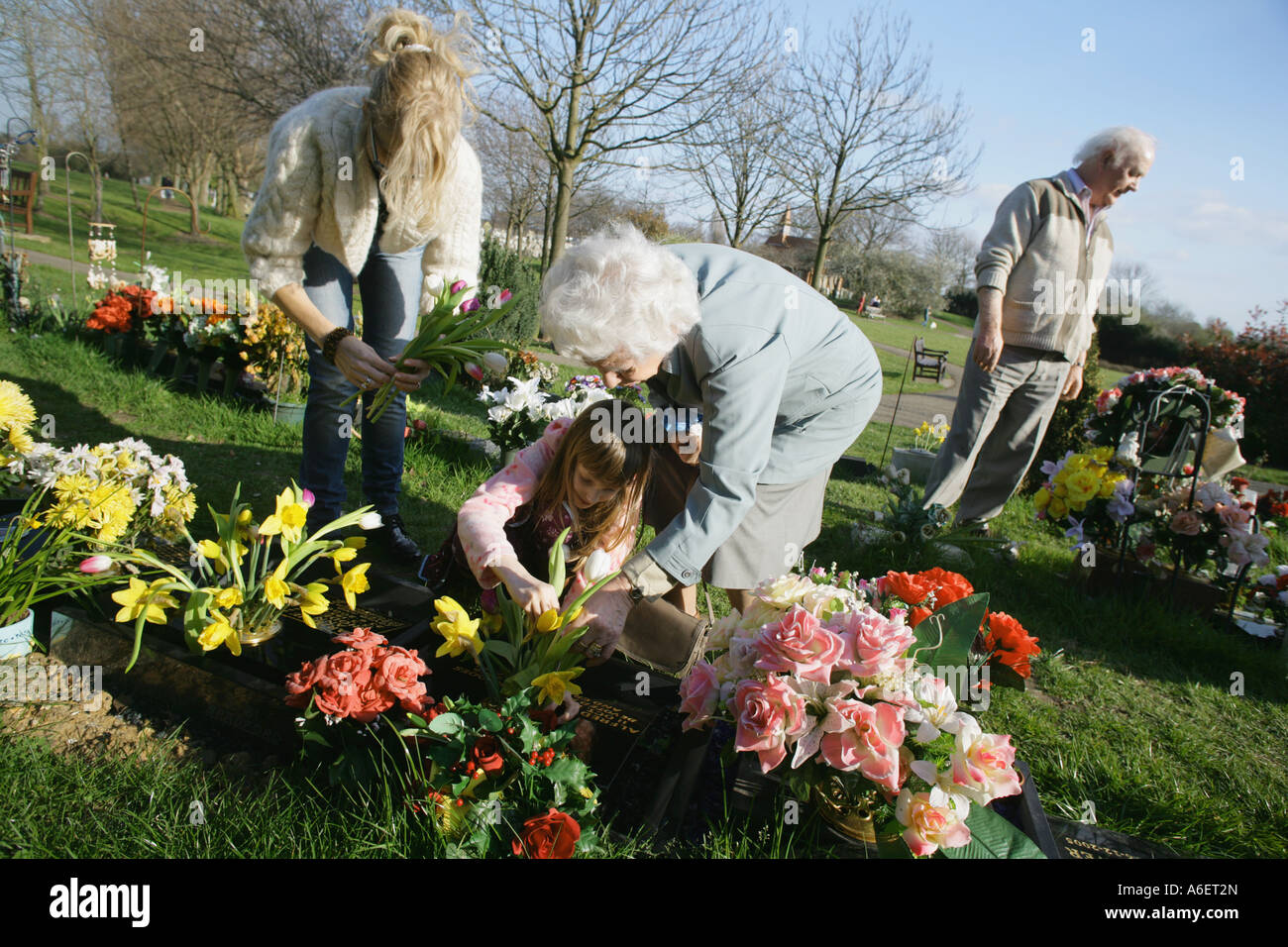 Family members looking after the grave of a loved one at a cemetary, Essex, England, UK. Stock Photo