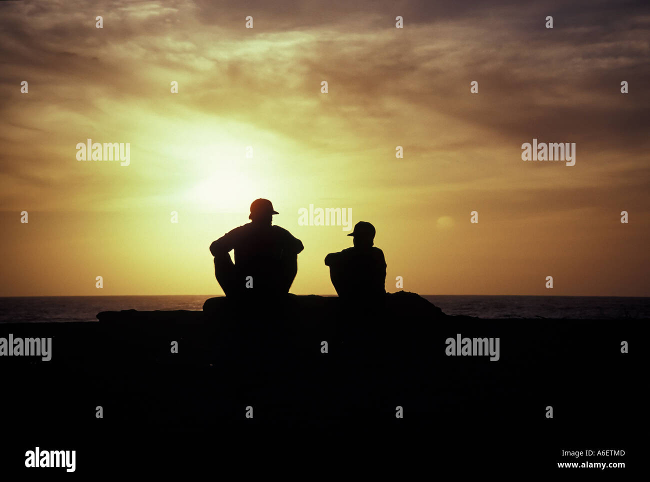 A father and son watch the sunset Stock Photo