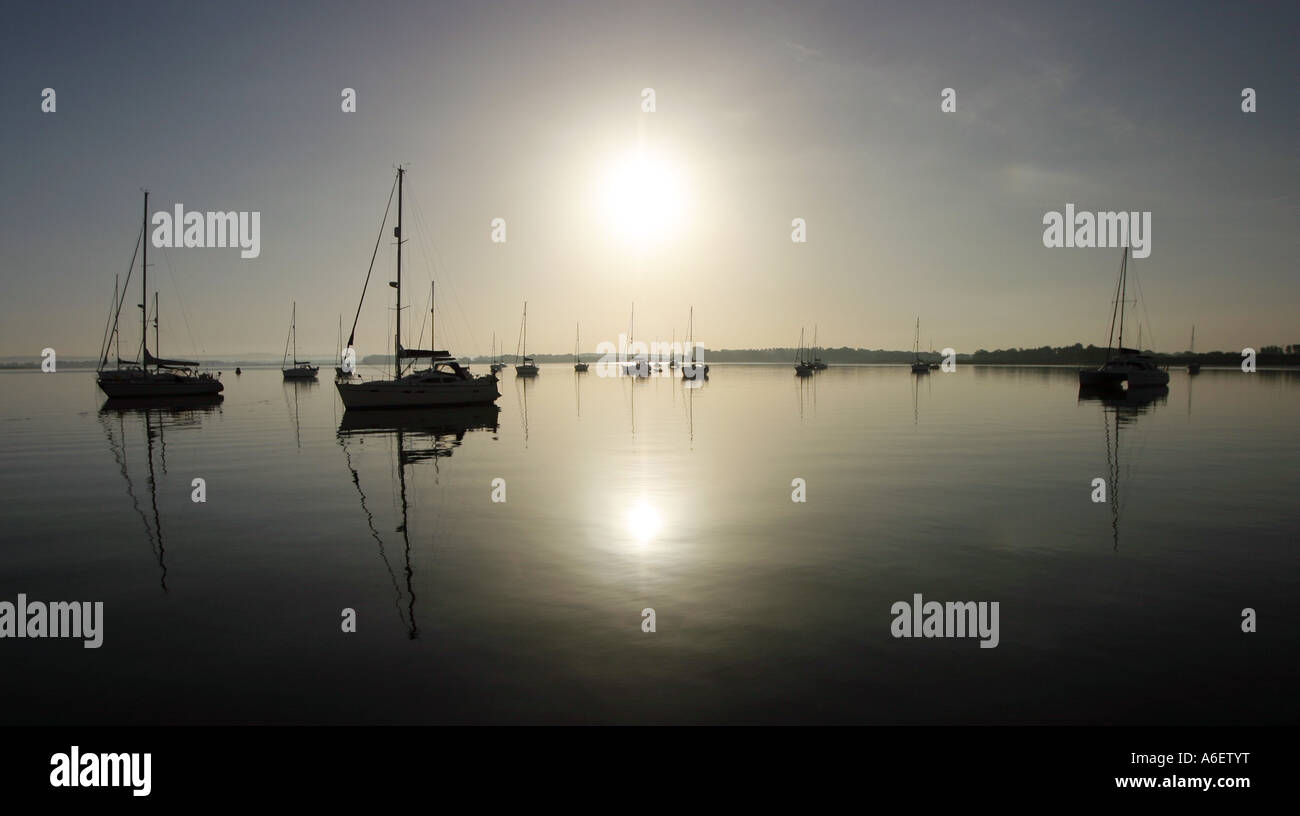 Sunrise over the sea at East Head, Chichester with moored yachts, Sussex, England Stock Photo