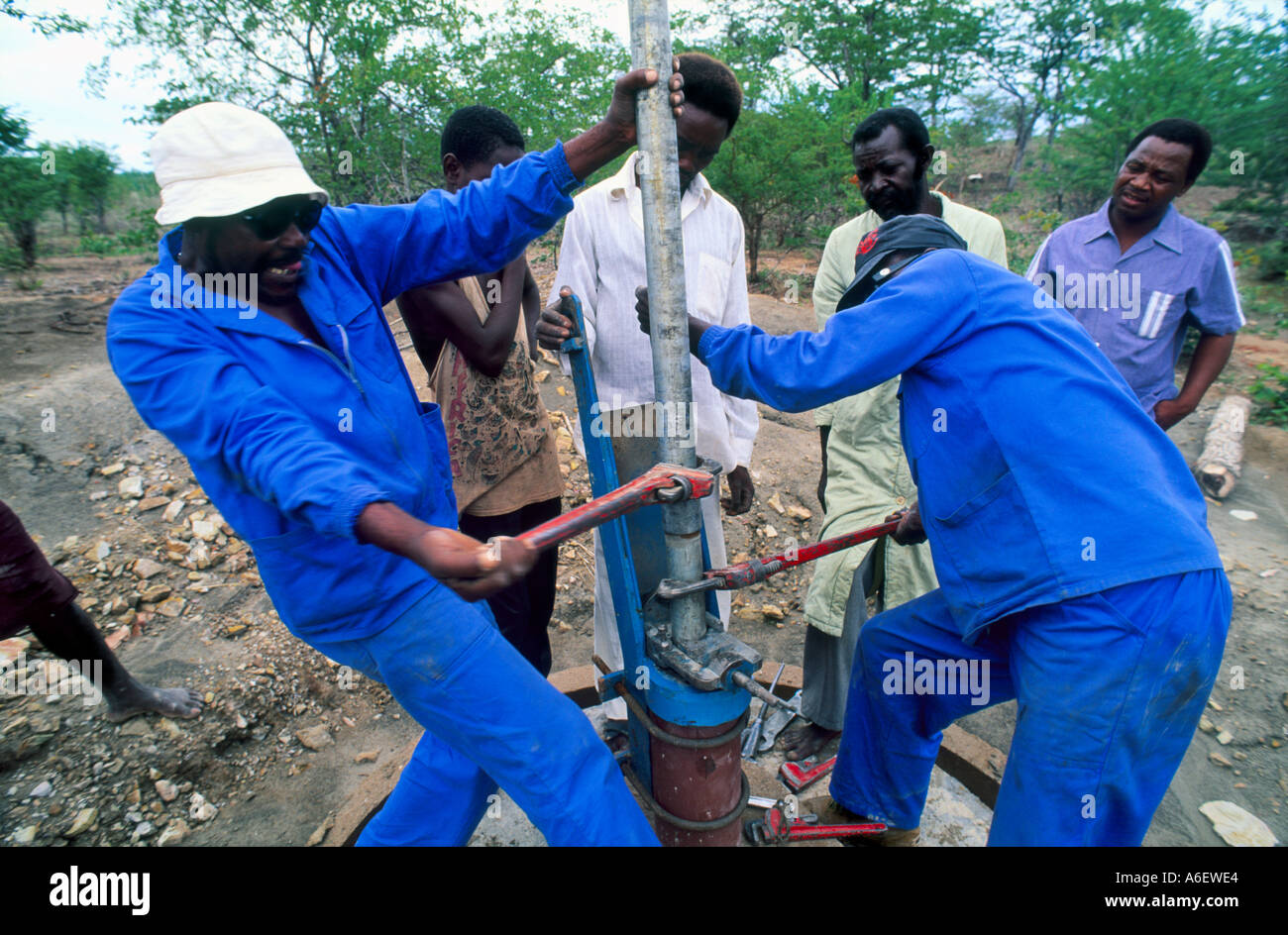 Water engineers fitting a pump head to a well. Zimbabwe Stock Photo