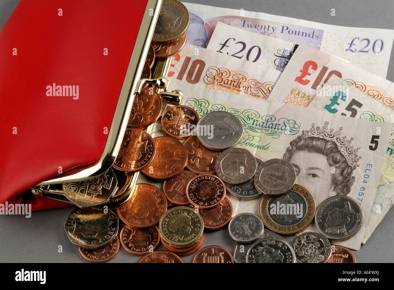 Money and a red leather purse Cash Loose change Silver and copper coloured coins Notes United Kingdom coinage of the realm Stock Photo