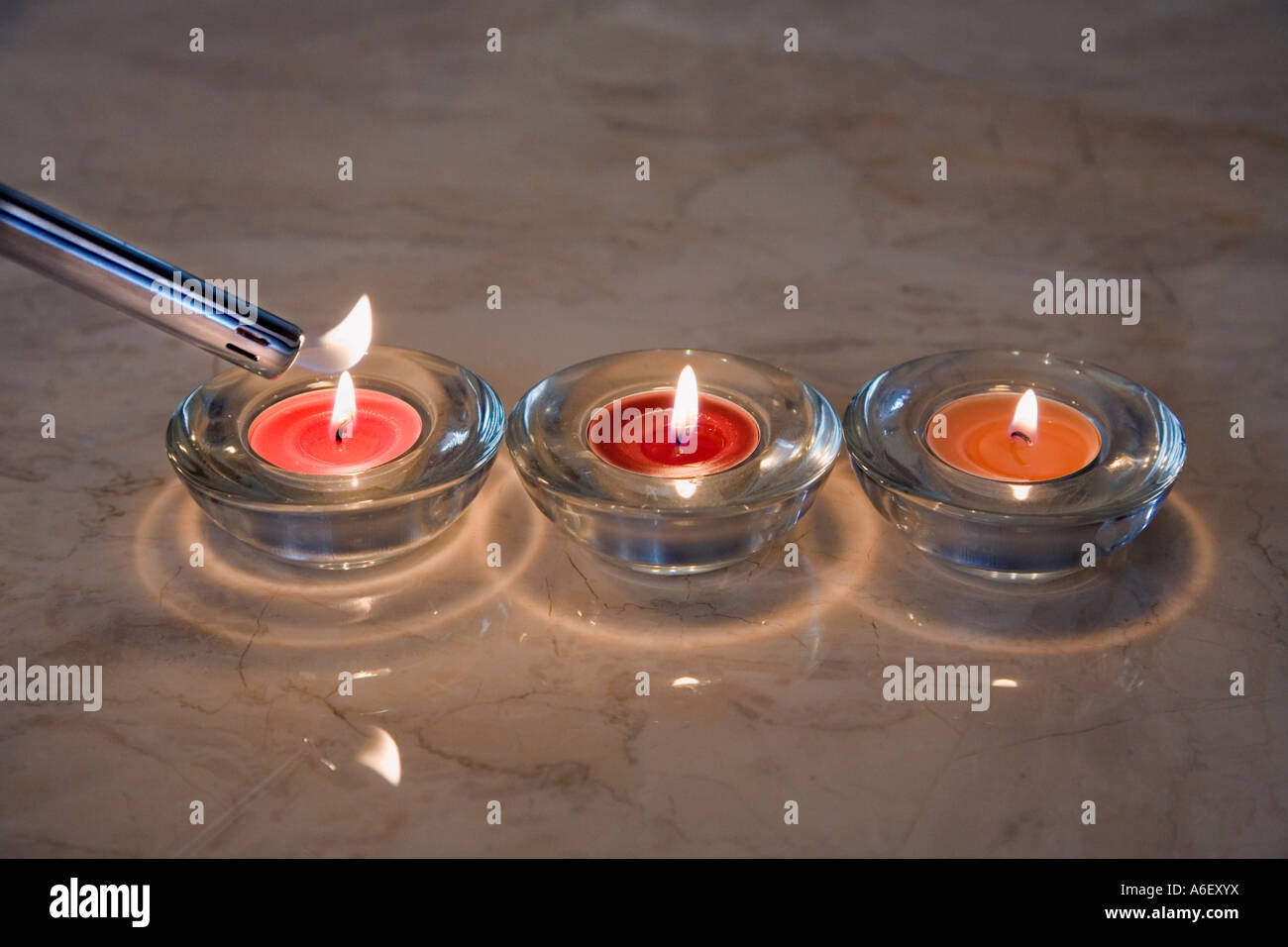 THREE TEA CANDLES BEING LIT Stock Photo Alamy