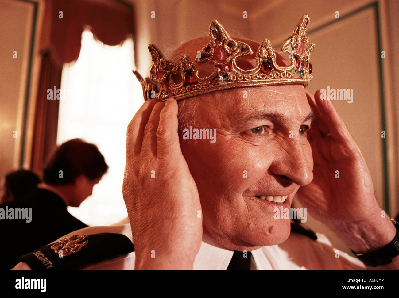 A Security Man Tries A Crown For Size At A Costume Sale By The Royal