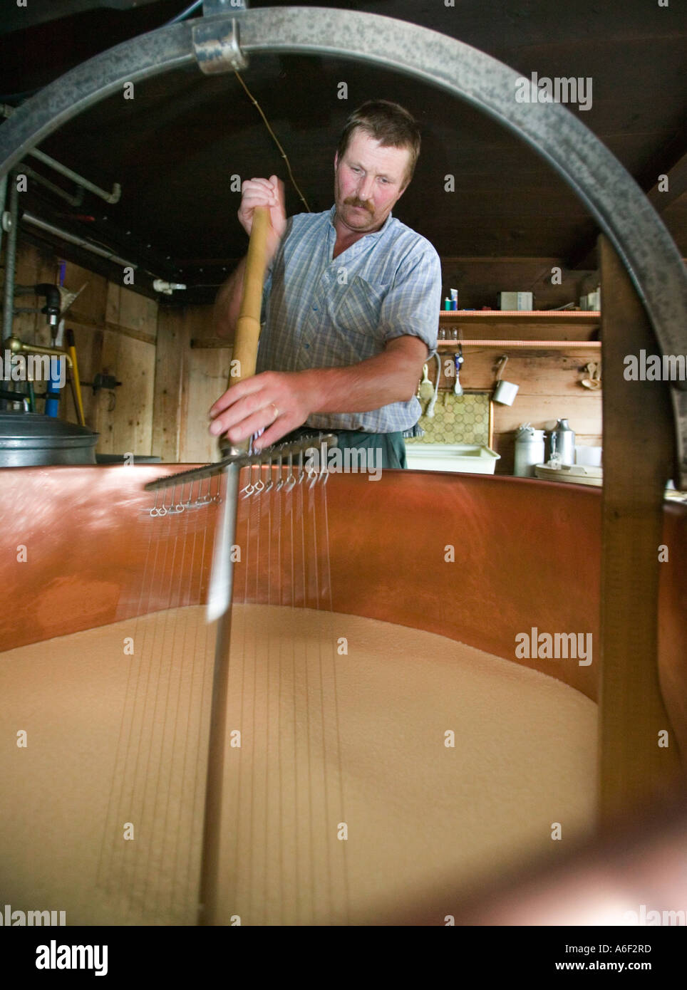 Gstaad, CHE, Alp 'Hintere Walig' Farmer stirrs the fresh milk in a big cheese cauldron Stock Photo