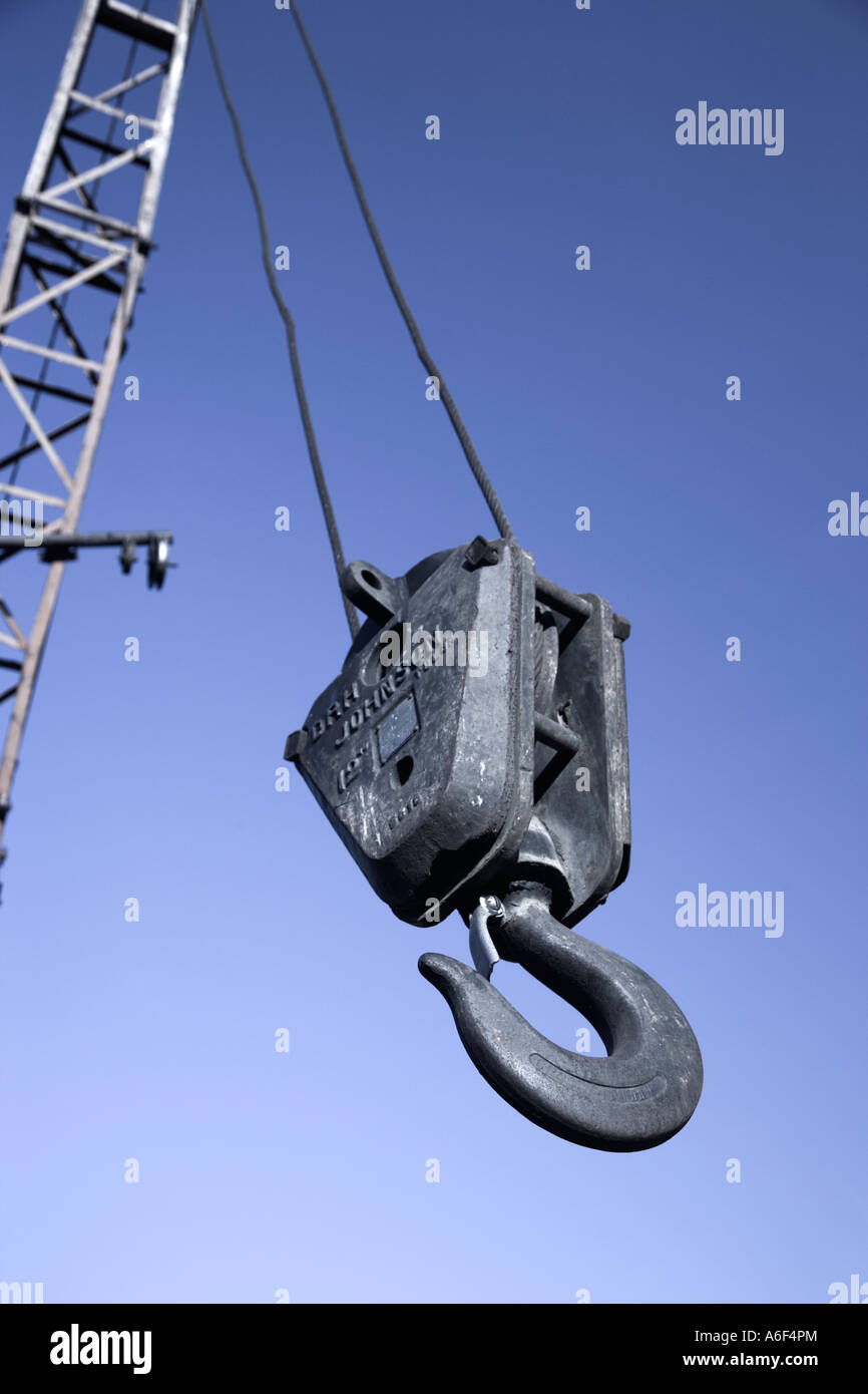 Old pulley hook hanging from cable boom. Stock Photo