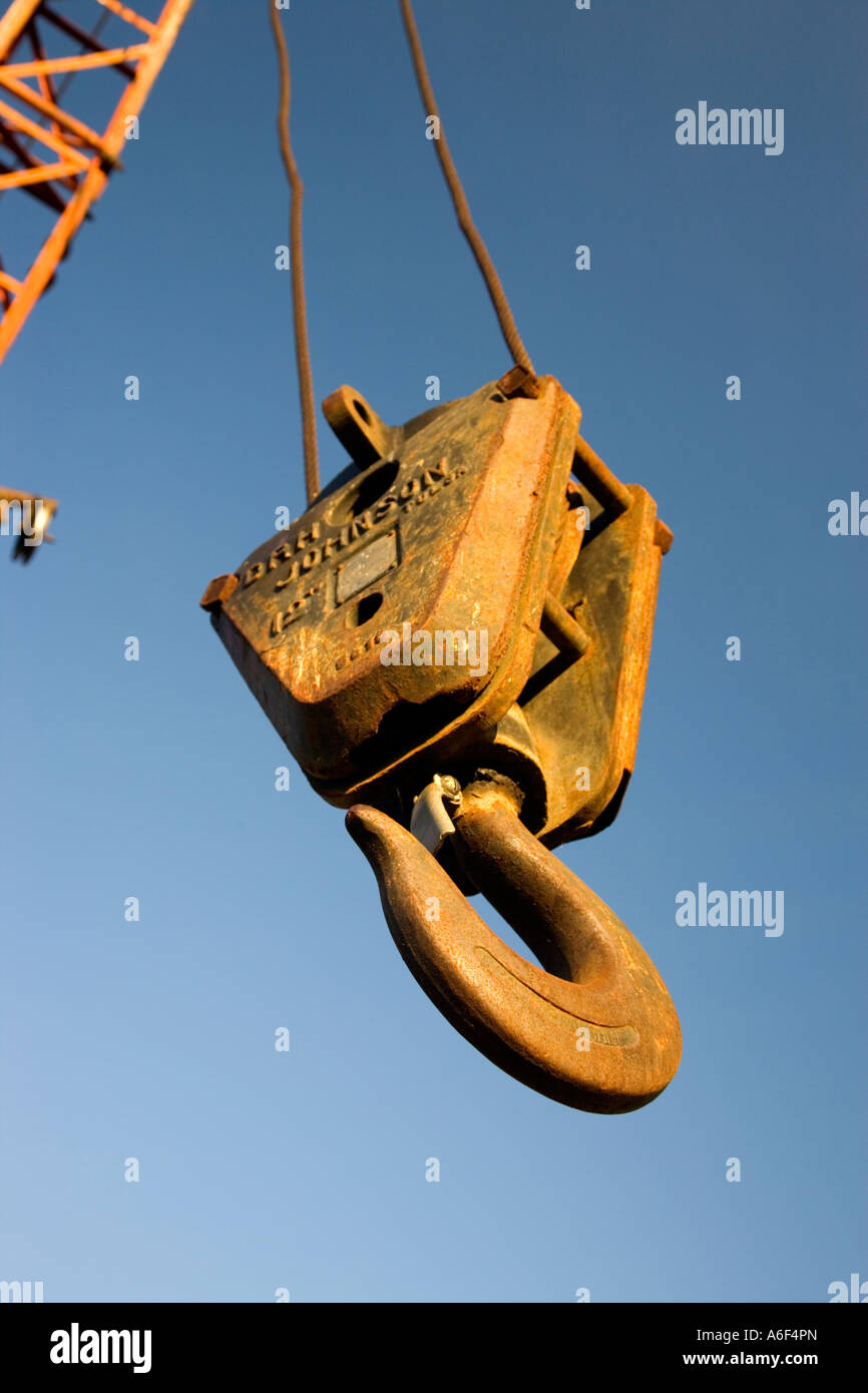 Old rusty pulley hook hanging from cable boom. Stock Photo