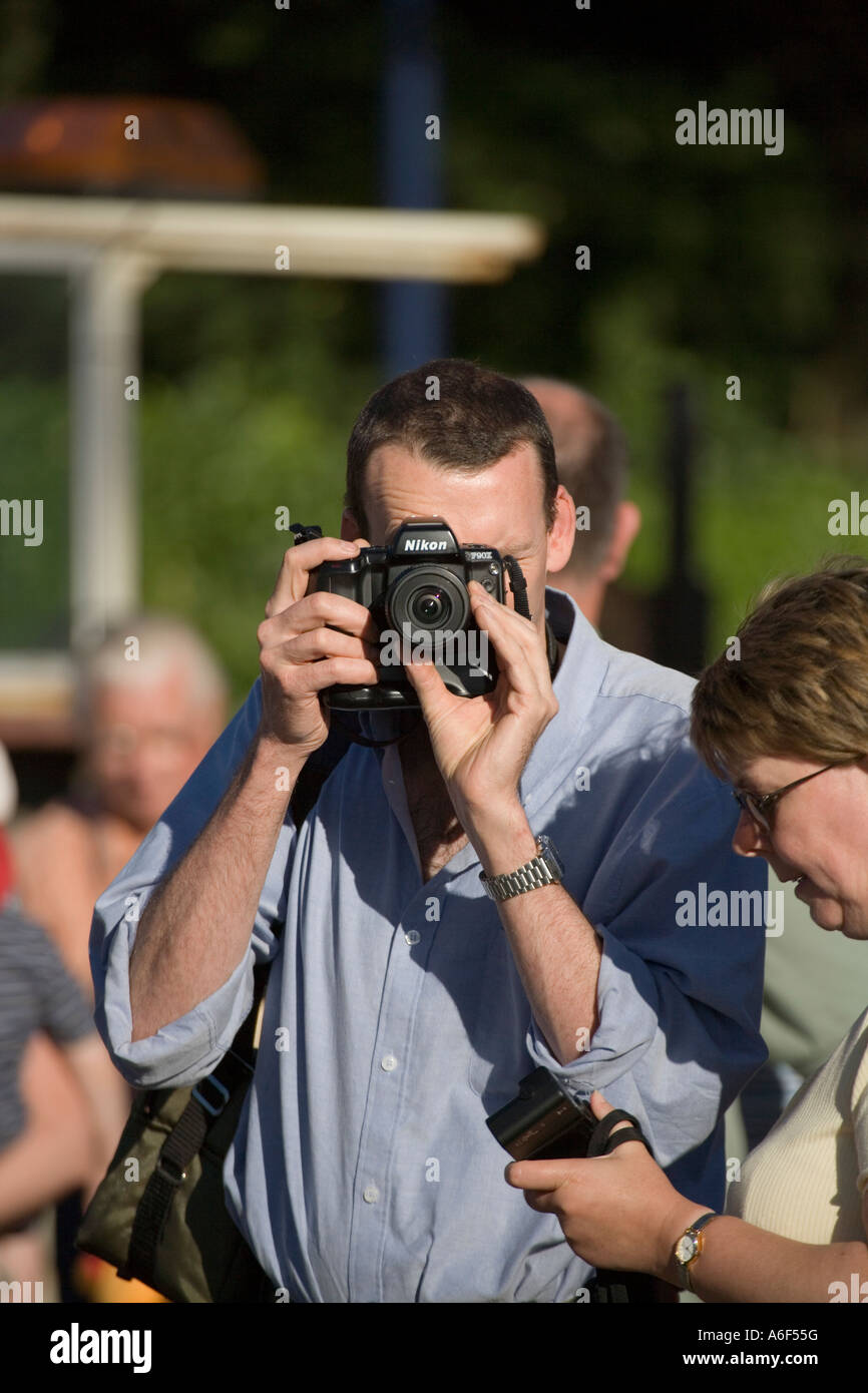 Man taking a photograph with a Nikon F90X SLR camera Stock Photo - Alamy