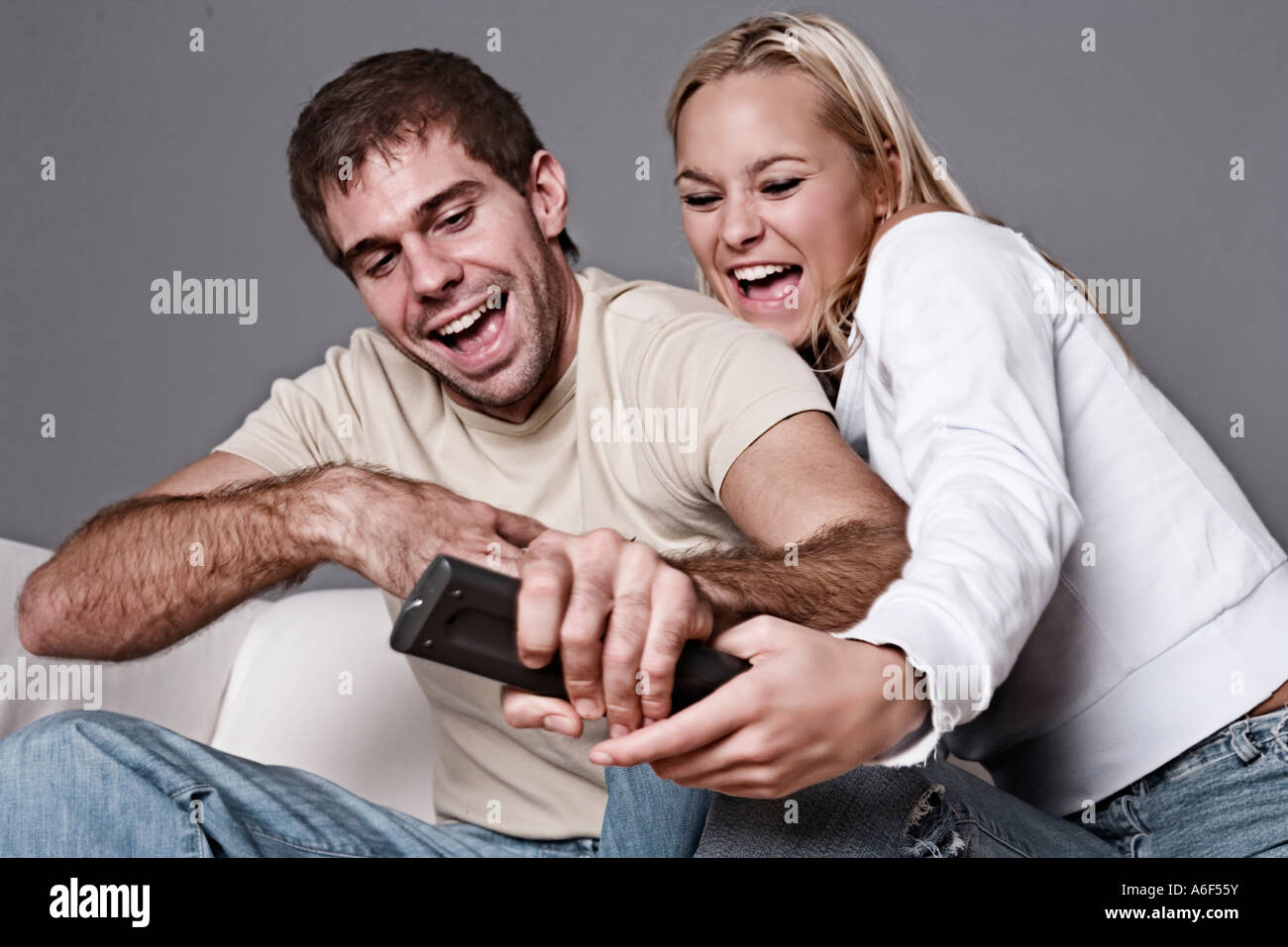 Man & woman fighting over remote control Stock Photo