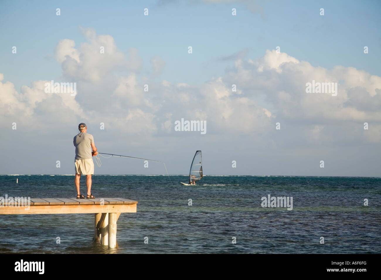 BELIZE Ambergris Caye Adult male practice fly fishing from dock and