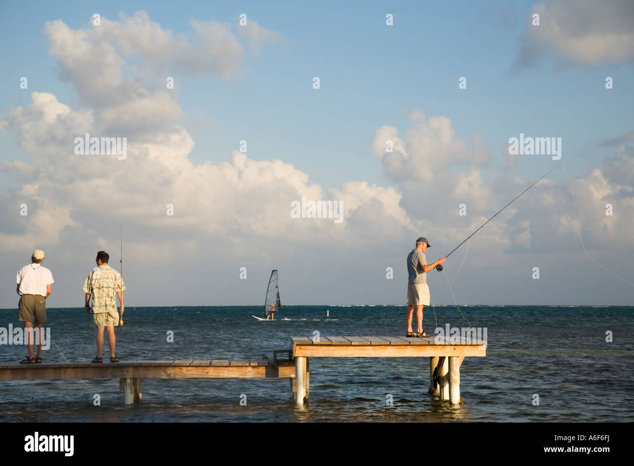 BELIZE Ambergris Caye Three male adults practice fly fishing casting
