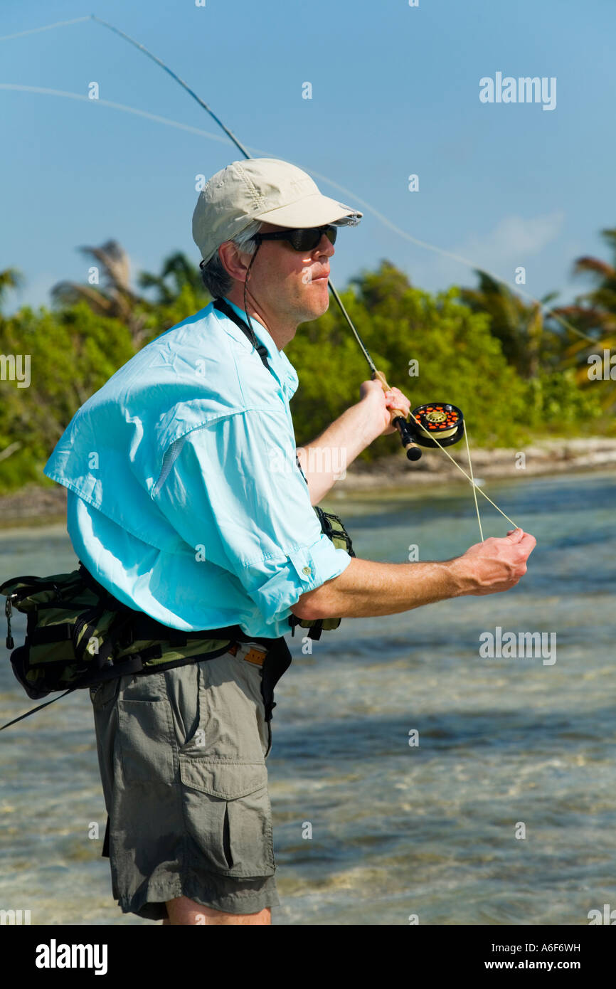 BELIZE Ambergris Caye Adult male fly fishing in flats along shoreline