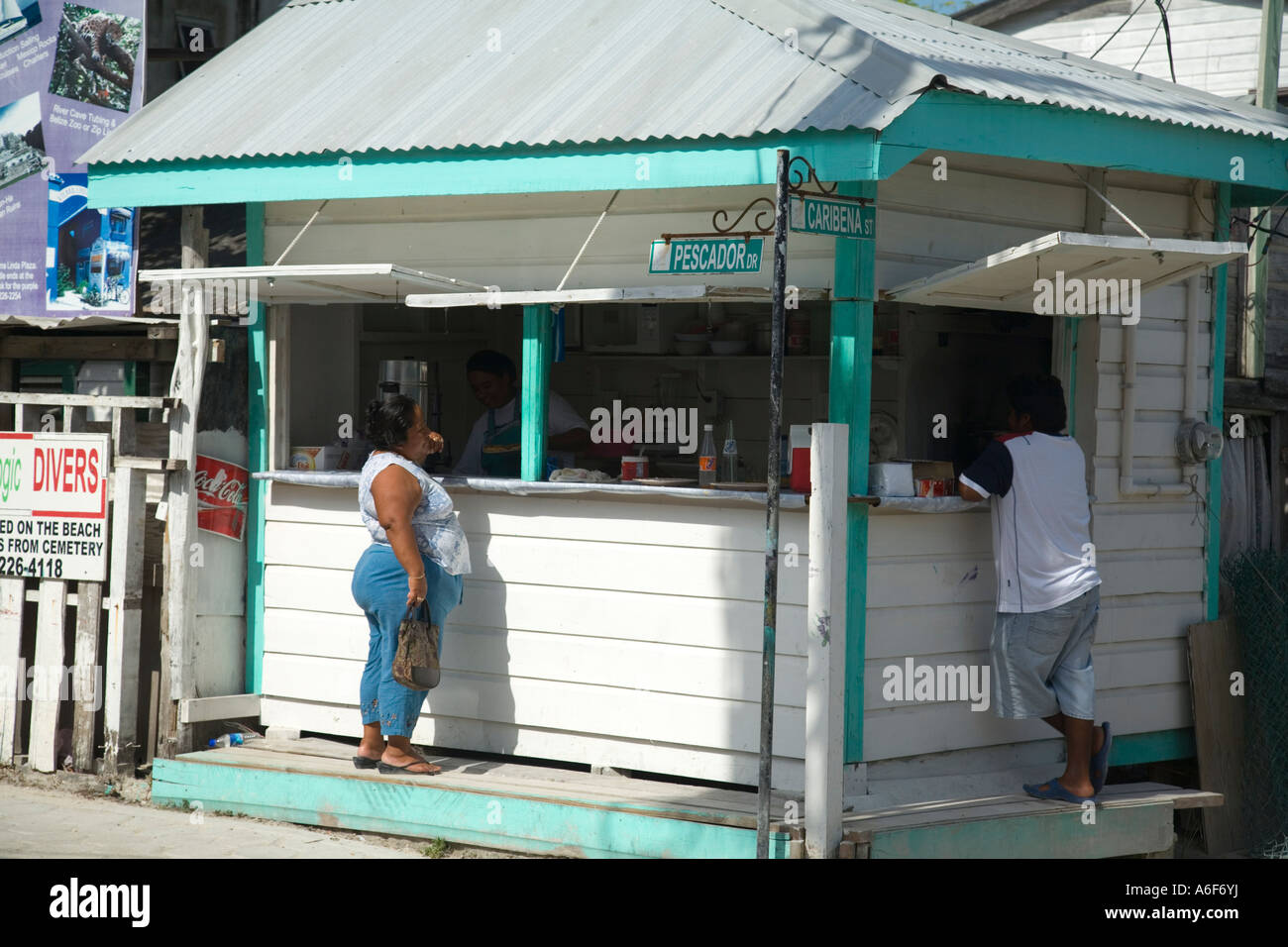 BELIZE San Pedro on Ambergris Caye Man and woman stand at restaurant window and order food street intersection Stock Photo