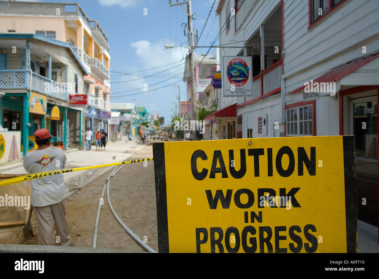 BELIZE San Pedro on Ambergris Caye Workman stand next to Caution Work in Progress Sign paving city street Stock Photo