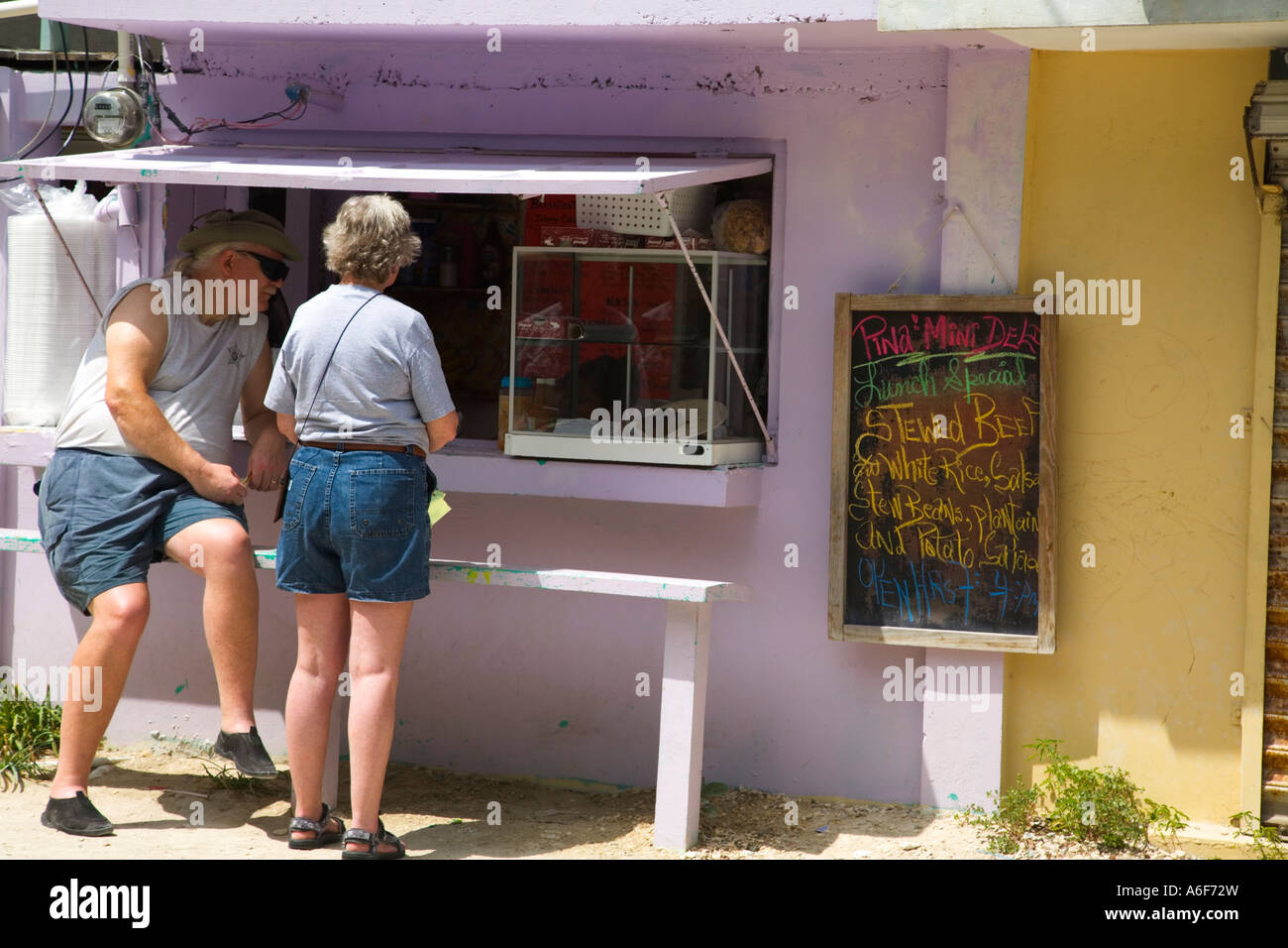 BELIZE San Pedro on Ambergris Caye Man and woman order at open restaurant window menu written on chalkboard Stock Photo