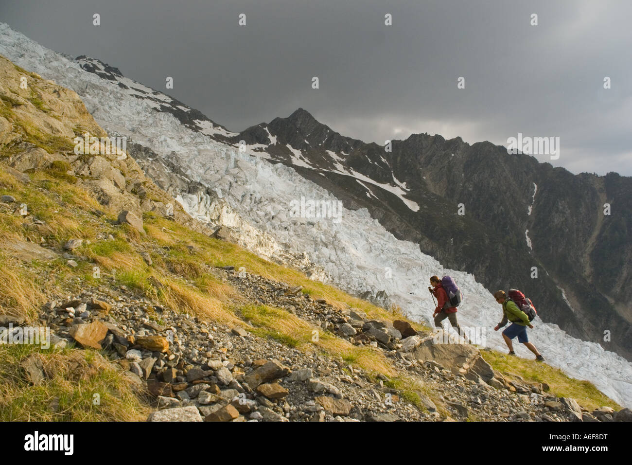 A couple hiking next to a glacier in the French Alps near Chamonix Stock Photo