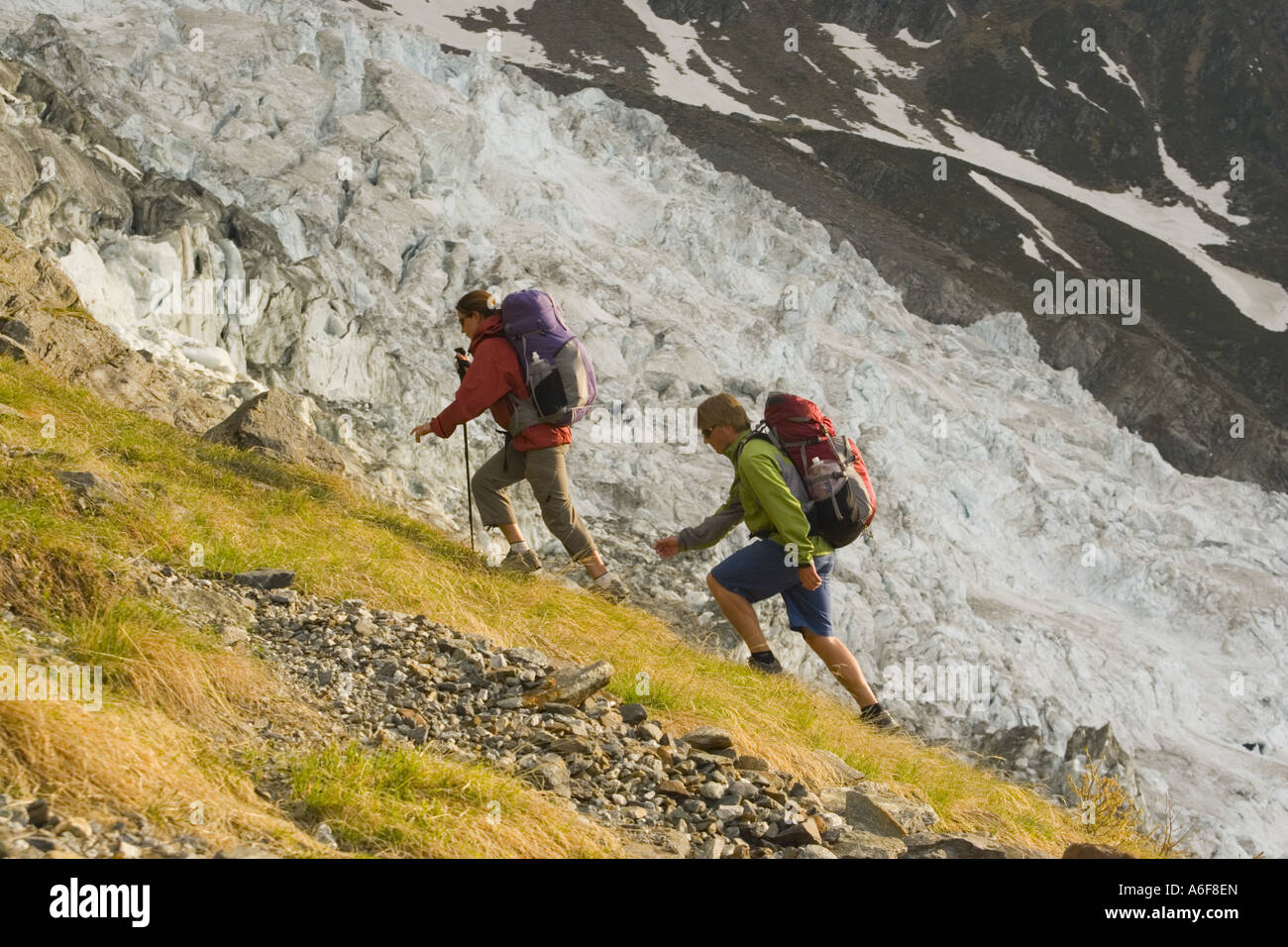 A couple hiking next to a glacier in the French Alps near Chamonix Stock Photo