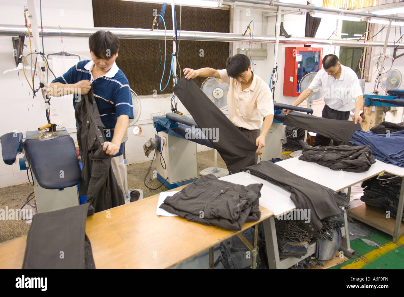 SHENZHEN GUANGDONG PROVINCE CHINA Workers ironing finished clothing in
