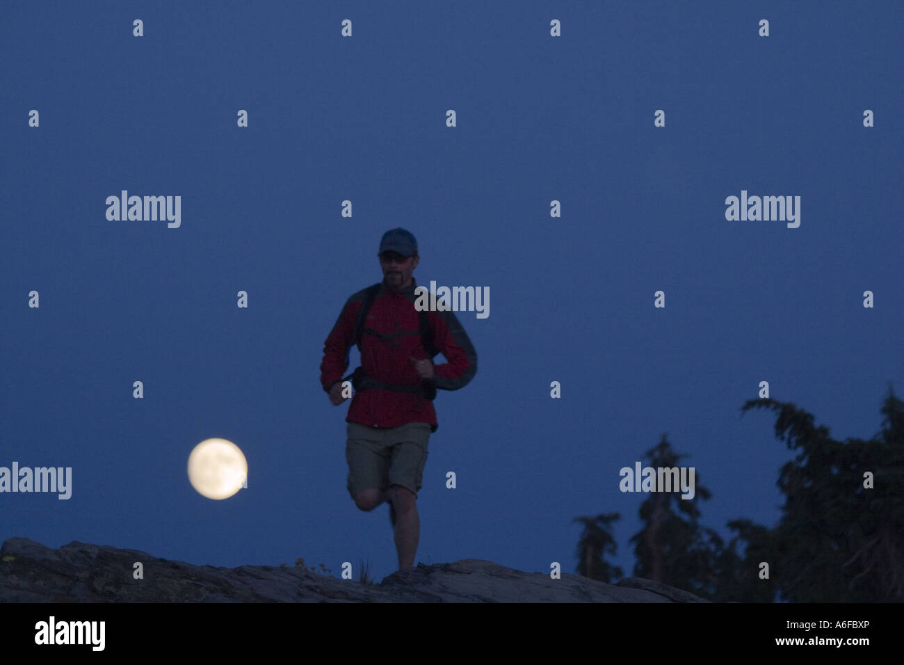 Running On Rim A man running and the full moon on the Tahoe Rim Trail above Lake Tahoe ...
