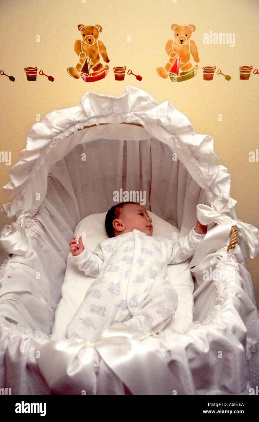 New born baby boy 5 weeks old resting in crib cot nursery bedroom wearing baby grow one piece 1997 archive image stick on wall decorations England UK Stock Photo