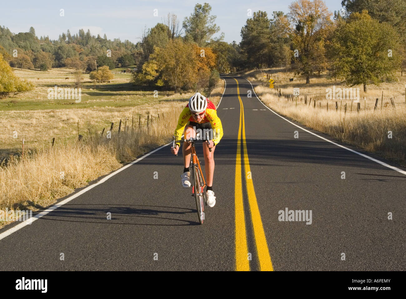 A male teenage bike racer riding on a country road near Groveland