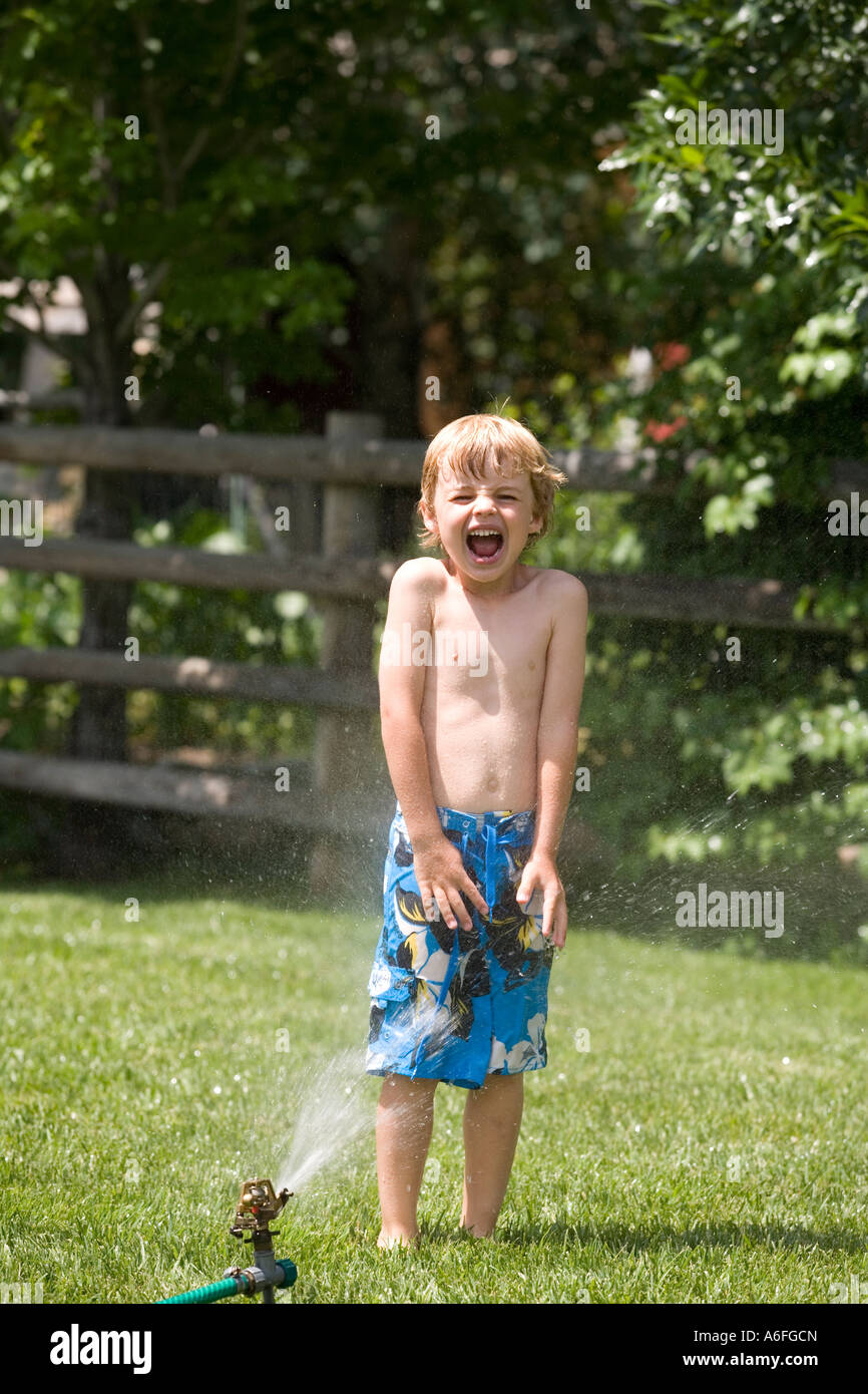Child Running Through the Sprinklers Stock Photo Alamy