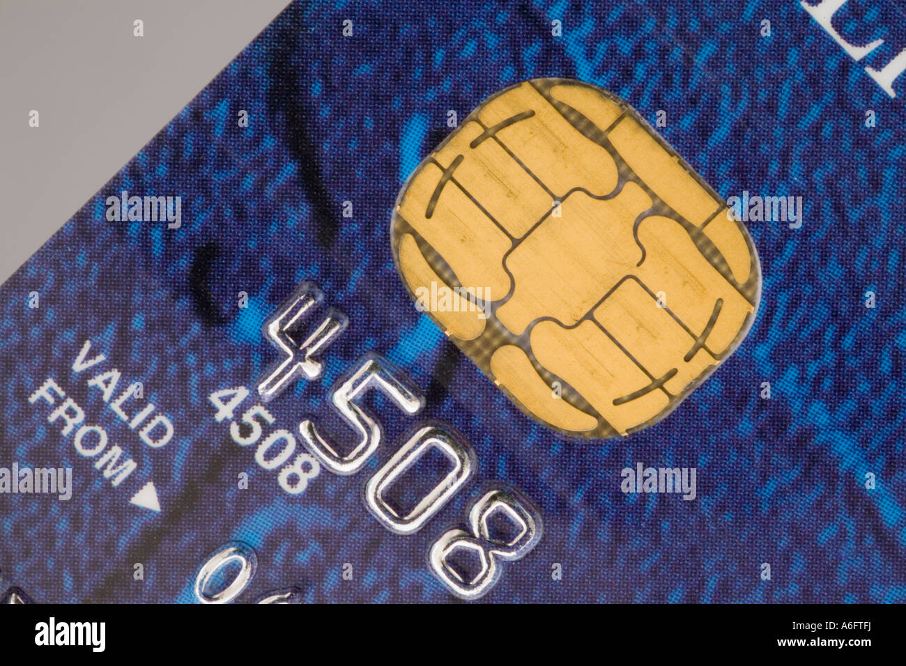Electronic micro chip in close up on blue credit or debit bank card for chip and pin security. England UK Britain Stock Photo