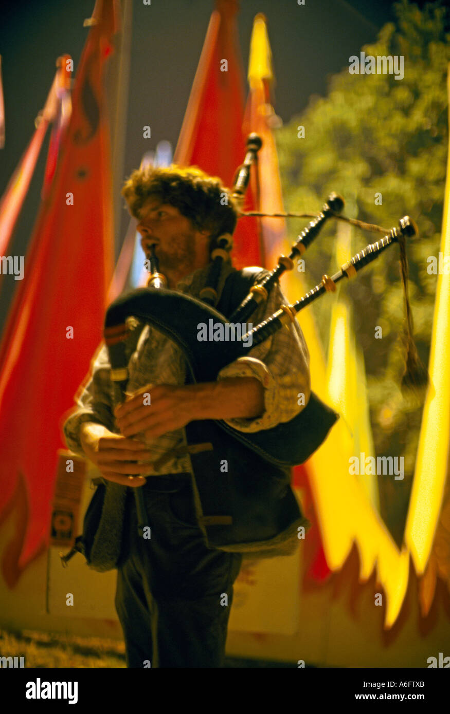 Man playing bagpipes at night at Glastonbury Festival of Contemporary Performing Arts June 1999