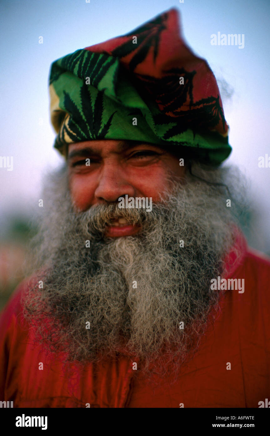 Asian or Caribbean man with long grey beard smiling at Glastonbury Festival Stock Photo
