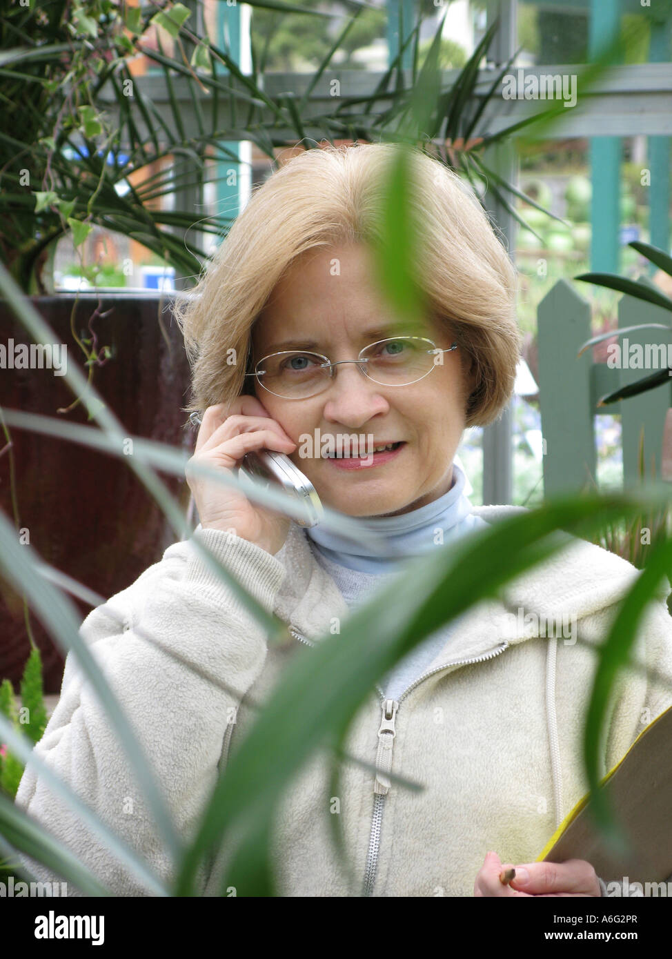 Woman talking on cell phone while shopping at garden store Seattle Washington Stock Photo